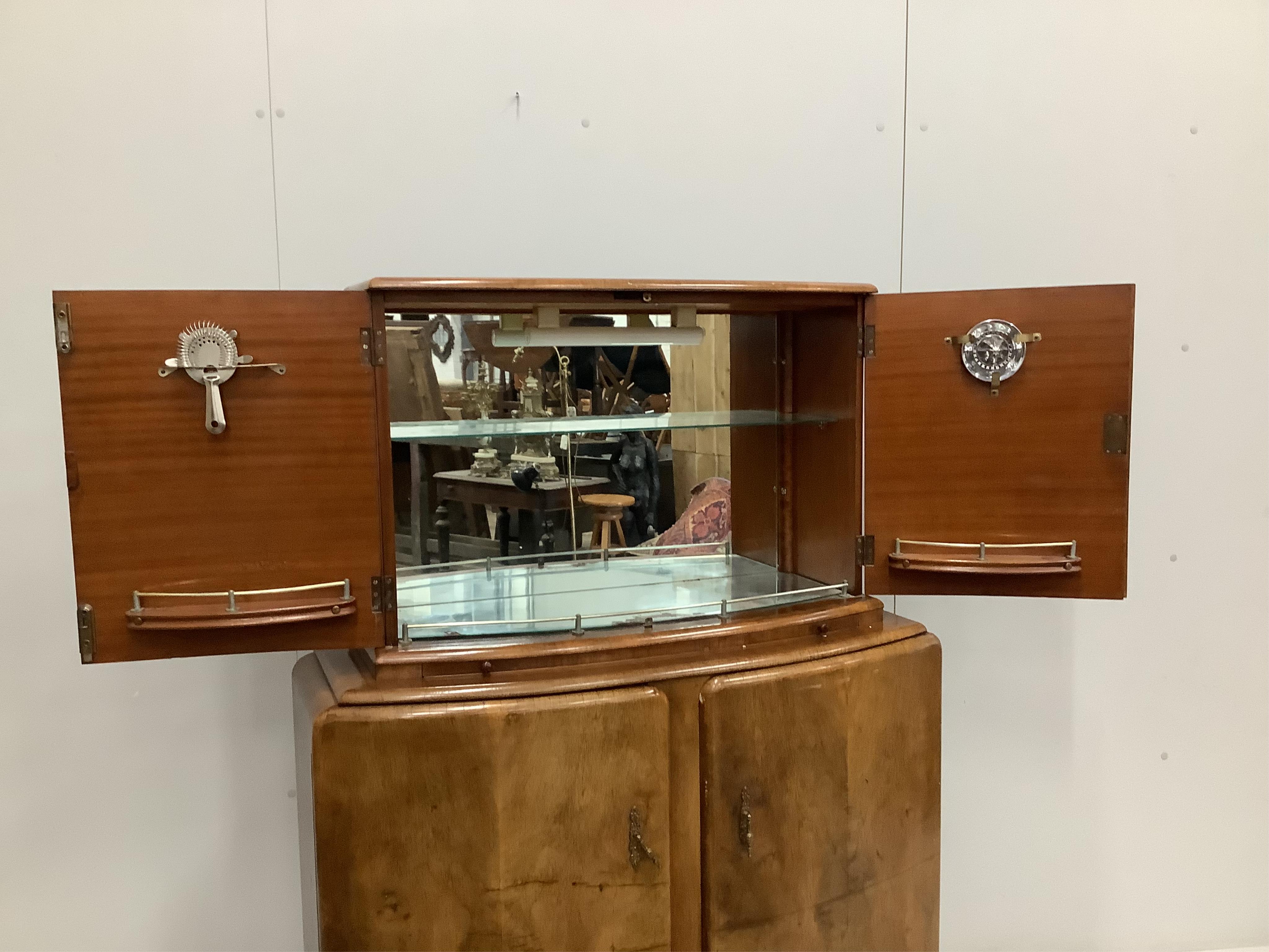 An Art Deco style walnut cocktail cabinet, width 102cm, depth 38cm, height 144cm. Condition - fair